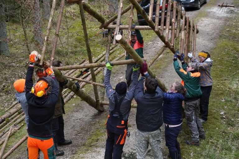 zwei Männer bauen einen Hochsitz